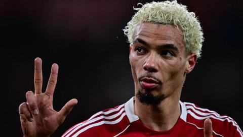 Hugo Ekitike gestures the score to Newcastle fans at Anfield
