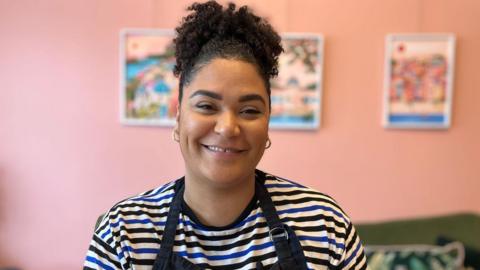 Tyra Packer smiles at the camera while decorating a cookie