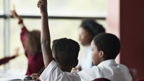 Raised hands in classroom