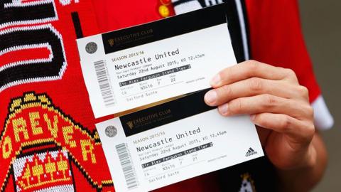 A supporter holding two tickets for Manchester United against Newcastle United