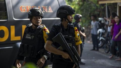 Indonesian police patrol outside a church after a suicide bomb in Surabaya. Photo: 13 May 2018