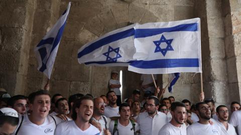 Israeli nationalists carry flags during the annual Jerusalem Day march in the Old City of Jerusalem on 10 May 2021
