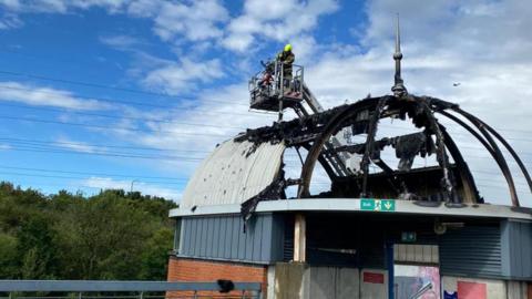 A firefighter above the fire-damaged stairwell