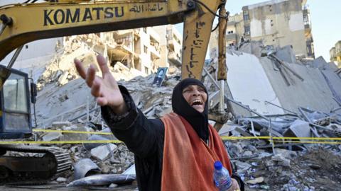 A woman reacts after an Israeli air strike destroyed a multi-storey building in the southern Beirut suburb of Chiyah (21 October 2024)