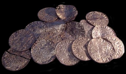 Sixteen Norman coins lying in a pile, they are known as the Chew Valley Hoard