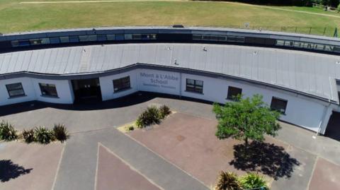 Aerial view of Mont à l’Abbé School’s secondary building, showing the curved modern building and surrounding grounds.