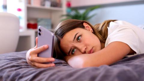 A teenager looking at mobile phone 