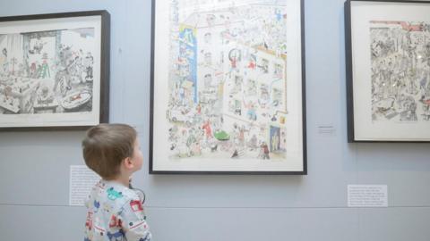 A young visitor to Rugby Art Gallery and Museum takes a closer look at a Chris Orr print on the wall during the artist's Domestic Fantastic: Prints and Paintings exhibition