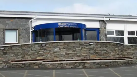 The front entrance to the hospital, which has a blue revolving door.