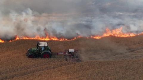Tractor with burning field in background
