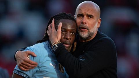 Manchester City boss Pep Guardiola hugs Jeremy Doku