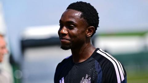 Anthony Munda head and torso shot looking ahead with gentle smile, wearing black Newcastle United training kit