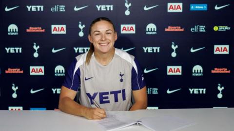 Kirsty Hanson poses for a photo while signing a Tottenham contract