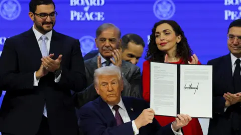 Trump holding document as others applaud