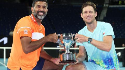 Rohan Bopanna and Matthew Ebden pose with the 2024 Australian Open men's doubles trophy