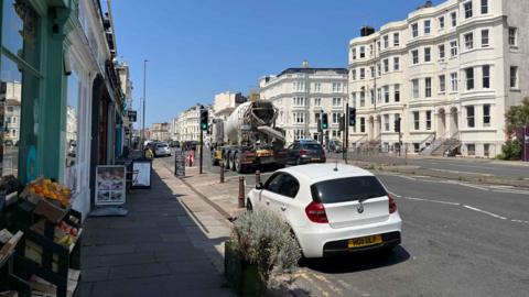 The A259 in hove which has a parade of independent shops with fruit and signage outside. There are currently two lanes which would go down to one lane
