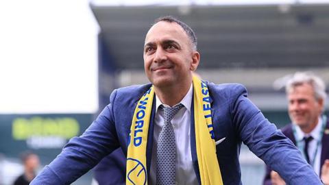 Paraag Marathe looks on with Leeds scarf