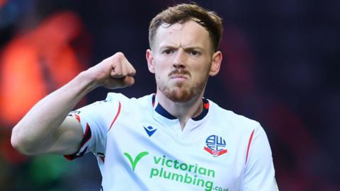 George Johnston punches the air in celebration during a match for Bolton.