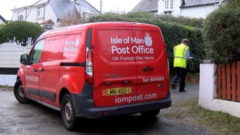 Post van and postman delivering post