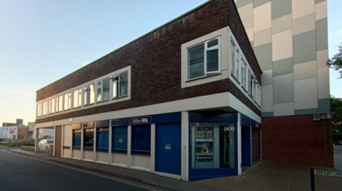A building on a corner. There is signage for a William Hill shop.