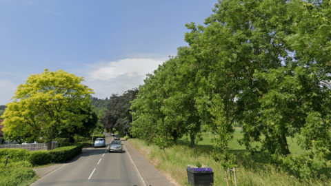 A general view of Brockham Lane in Brockham with two lanes and a tree-lined country road