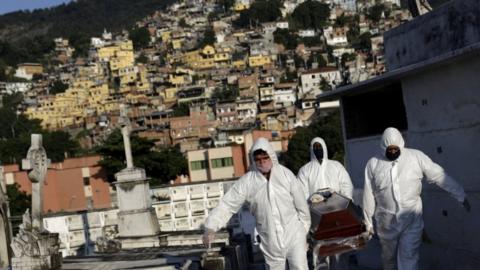 Gravediggers carry the coffin of Avelino Fernandes Filho, 74, who passed away from the coronavirus disease (COVID-19), during his funeral in Rio de Janeiro, Brazil, May 18, 2020.