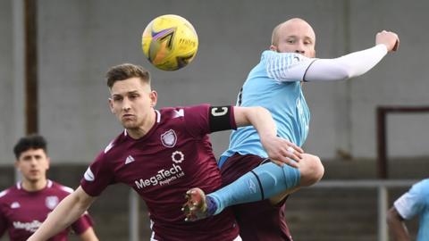 Liam Boyce of Hearts challenges for the ball