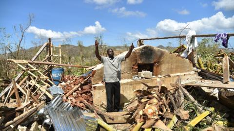 A man gestures while standing in his house in Deson, near Les Cayes in south-west Haiti.