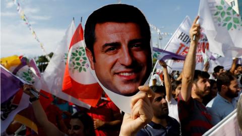 A supporter of the pro-Kurdish Peoples" Democratic Party (HDP) holds a mask of their jailed former leader and presidential candidate Selahattin Demirtas during a rally in Ankara, Turkey, June 19, 2018