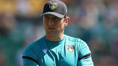 Northampton Saints director of rugby Phil Dowson watching his team train before kick-off with his arms folded.