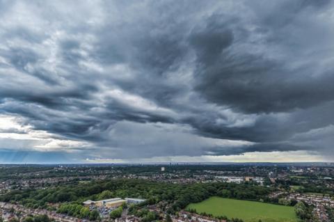 Landscape with heavy rain falling in the distance beneath a dramatic sky in Chingford, Greater Lon