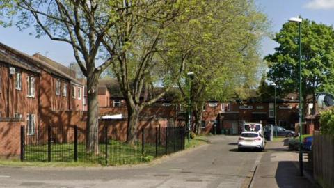 A street with houses and trees.