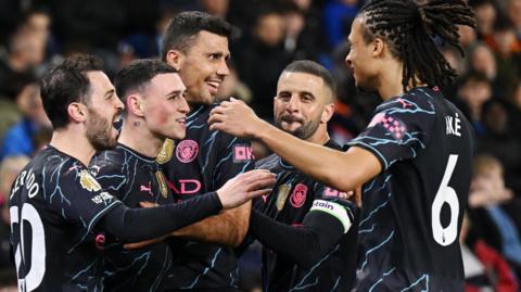 Manchester City players celebrate a  goal against Brighton