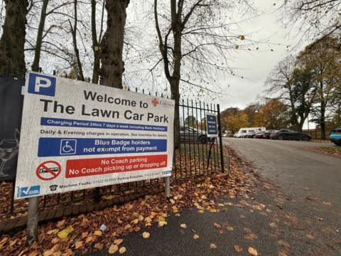 The entrance to The Lawn car park in Lincoln showing a sign and vehicles parked in the background