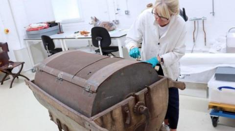 A council employee cleans a cheese making machine