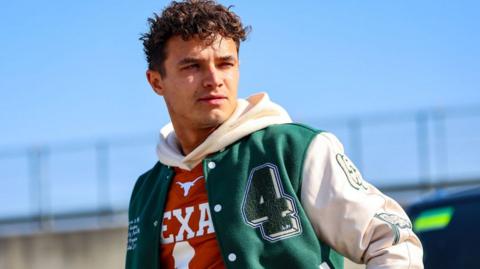 Lando Norris wearing a green and white bomber jacket at the Circuit of the Americas before the United States Grand Prix weekend