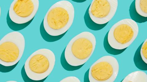 Halved hard-boiled eggs on a light blue background