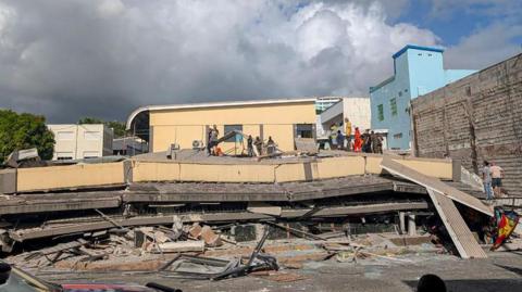 Rescue workers are seen at the site of a collapsed building after a powerful earthquake struck Port Vila, the capital city of Vanuatu, on December 17, 2024