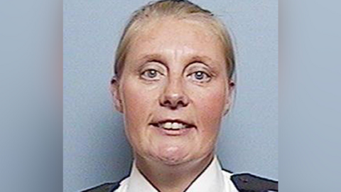 PC Sharon Beshenivsky looks at the camera. She has blonde hair tied back and is wearing a white shirt with black epaulettes