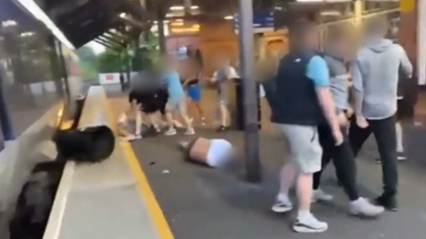 A screenshot from a video showing a man on the platform at Ballymoney trans station after he was kicked on the head by a group of young people