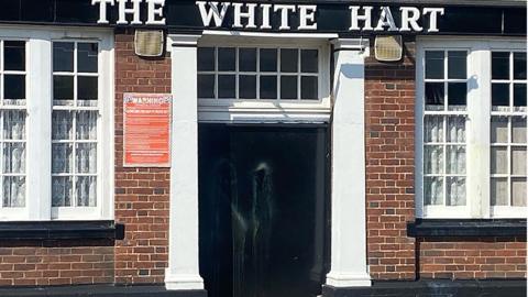 Paint smears on door of White Hart Inn