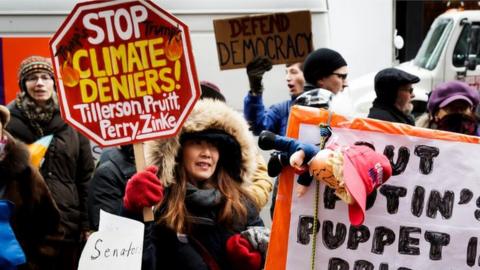 Protestors gather on the sidewalk in front of the offices of Senate Minority Leader Democrat Chuck Schumer as part of nationwide rally organized to protest the nominations of climate change deniers in the cabinet of US President-elect Donald Trump,