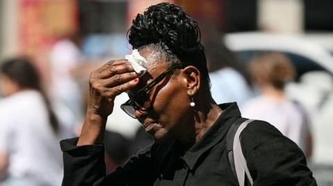 Woman mopping brow in heat