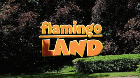 The entrance to the theme park Flamingo Land, which is displayed in large orange and yellow lettering.