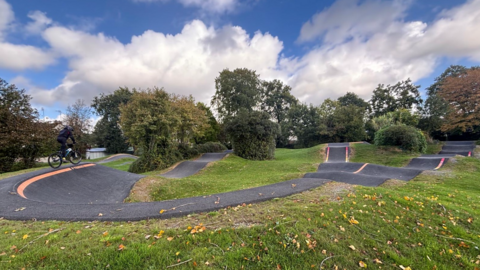 A child cycling on a rockpool with cloudy skies and tried in the background