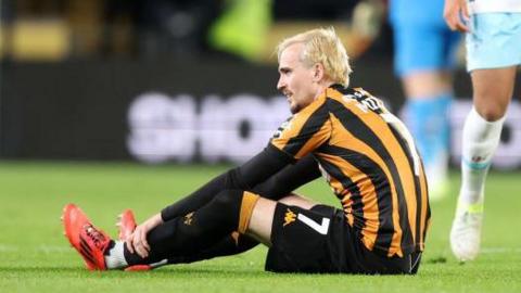 Liam Millar of Hull City goes down with an injury during the Sky Bet Championship match between Hull City AFC and Burnley FC at MKM Stadium on October 23, 2024 in Hull, England.