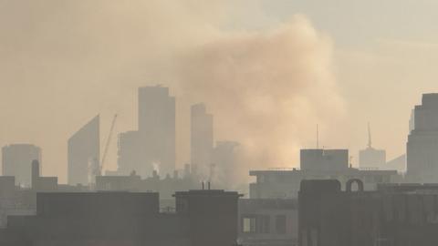 Smoke fills the air over the central London skyscrapers