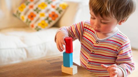 One-year old playing with building blocks