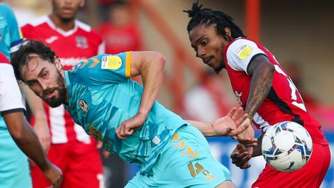 Ed Upson of Newport County and Jevani Brown of Exeter City compete for the ball