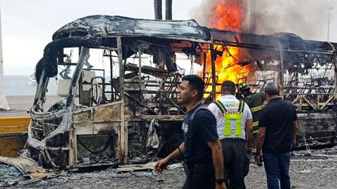 Firefighters work to put out a bus on fire in Puerto Vallarta, Mexico.